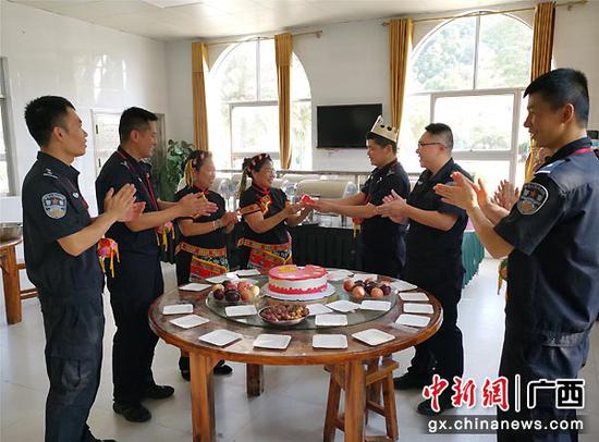 图为壮族“兵妈妈”向民警送上“党员政治生日蛋糕”。李慧明 摄 图为壮族“兵妈妈”向民警送上“党员政治生日蛋糕”。李慧明 摄
