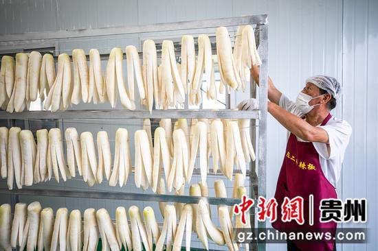 8月2日,村民在贵州省毕节市七星关经济开发区陈二平特色食品萝卜干生产车间里忙碌。