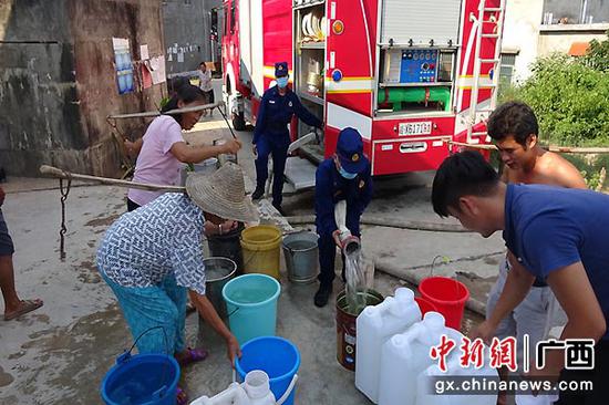 图为消防员给村民接水。消防供图 图为消防员给村民接水。消防供图