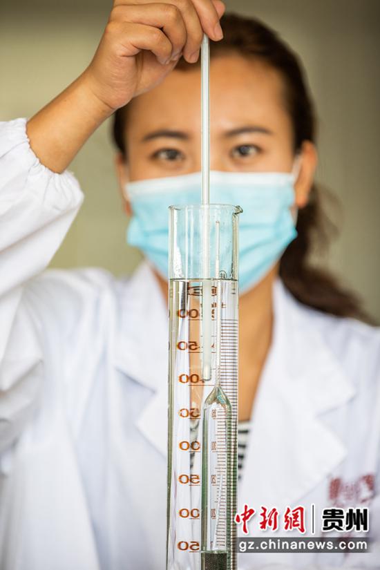 8月9日,工人在贵州省毕节酒厂的包装车间里检测产品的酒精度。