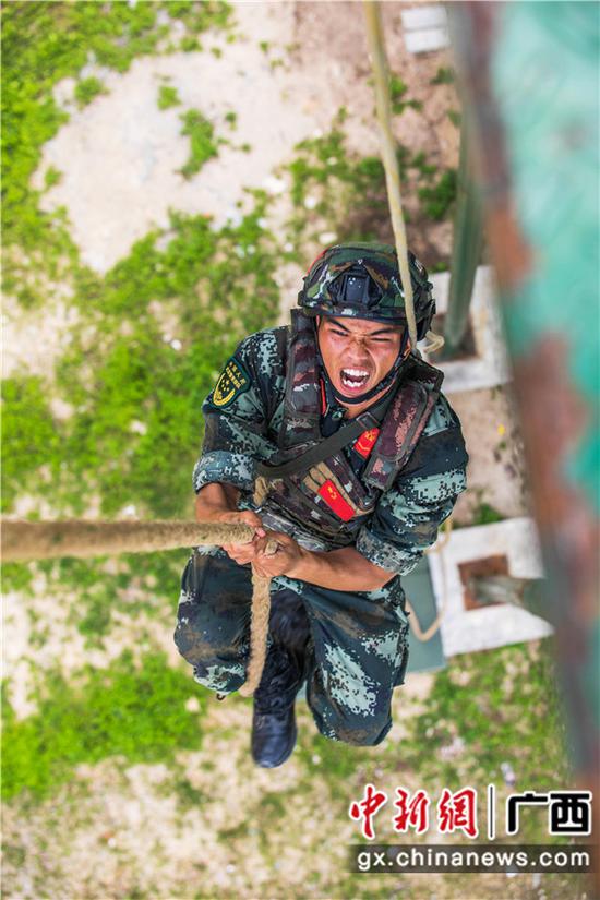 图为刘军进行攀登抓绳训练。