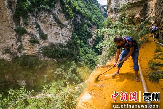 7月31日，在贵州省毕节市七星关区团结乡青林村，村民正在对建在悬崖峭壁上的法朗渠进行管护。
