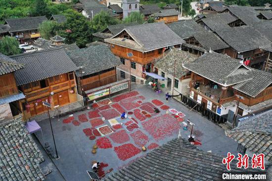 增冲侗寨村民在戏台前院坝晾晒辣椒(无人机照片)。吴德军 摄 增冲侗寨村民在戏台前院坝晾晒辣椒(无人机照片)。吴德军 摄