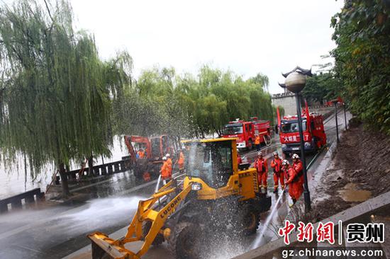 图为消防指战员在现场进行清淤工作。