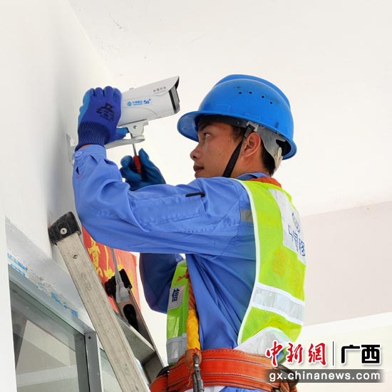 中国移动工作人员在田东县作登瑶族乡平略村陇灶屯安装摄像头。罗先彬 摄 广西百色:中国移动为民众脱贫致富插上腾飞的“翅膀”