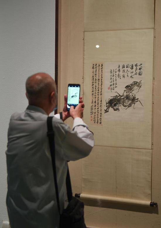 一位参观者驻足拍摄吴�之画作。 王刚 摄