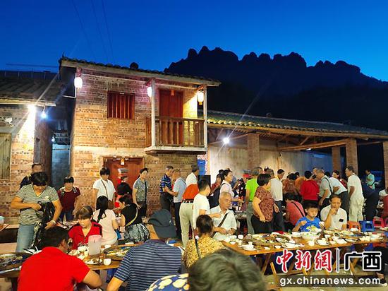 图为游客们参加瑶族特色长桌宴。茂南·金秀扶贫协作办 供图 图为游客们参加瑶族特色长桌宴。茂南·金秀扶贫协作办 供图