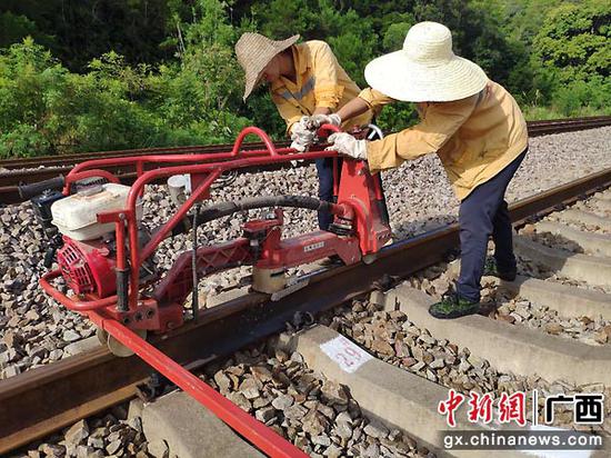 图为玉林工务段职工使用轻型打磨机进行打磨整治钢轨肥边病害作业。谭育俊 摄 图为玉林工务段职工使用轻型打磨机进行打磨整治钢轨肥边病害作业。谭育俊 摄