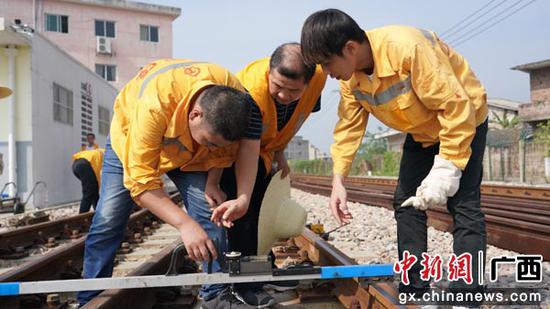 图为玉林工务段职工在线路上进行检查道岔区钢轨参数作业。谭育俊 摄 图为玉林工务段职工在线路上进行检查道岔区钢轨参数作业。谭育俊 摄