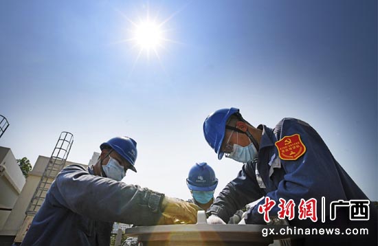 南方电网广西南宁供电局检修人员顶着烈日开展设备检修工作,保障电力可靠供应。马华斌 摄 南方电网广西南宁供电局检修人员顶着烈日开展设备检修工作,保障电力可靠供应。马华斌 摄