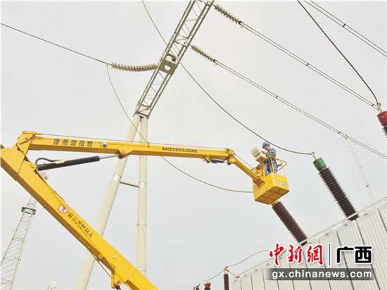 变电检修人员通过高空作业车到高空位置对变压器进行检修。易欢 摄 广西崇左:抓紧变电检修确保安全供电