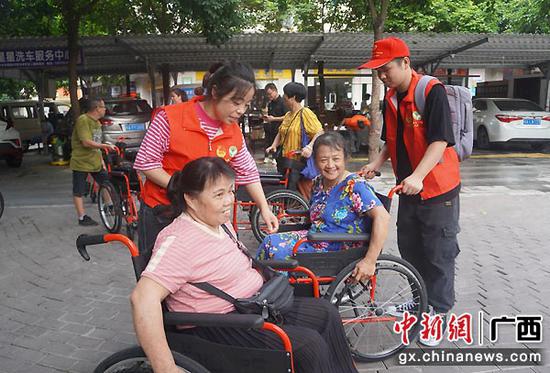 图为志愿者教残障人士使用新轮椅。