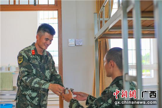 班长为新兵同志送上温水解渴。崔程 摄 武警广西总队各支队迎来首批新兵