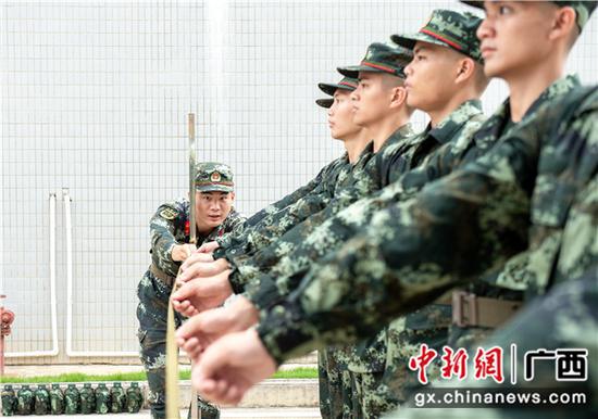 一名新训班长正在统一新兵摆臂高度。