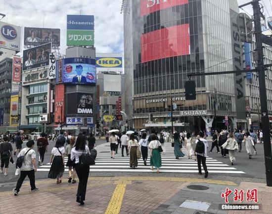 资料图:图为日本民众穿过涩谷车站前的交叉路口。 中新社记者 吕少威 摄