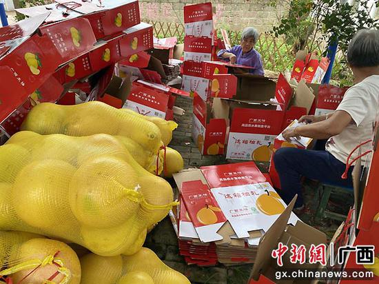 图为农户在包装柚子。 图为农户在包装柚子。