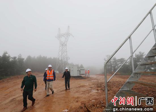 工作人员正在了解设备运行情况。韦荣军 摄
