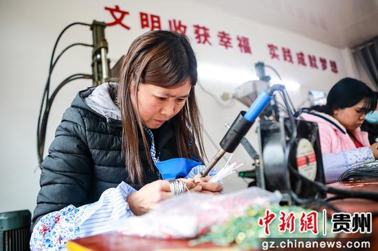 毕节市七星关区柏杨林街道易地扶贫搬迁安置点和美社区搬迁户彭玉洁妻子王敏在扶贫车间里上班 陈曦摄