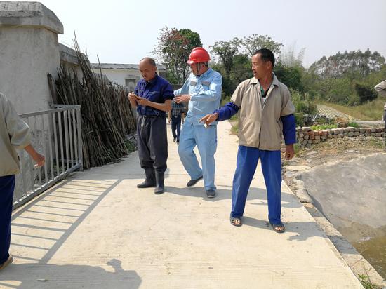 实现供电浇水后,村民和供电工作人员高兴地打电话报喜。梁渊文 摄 崇左扶绥供电局强力保障为“旱改水”项目“解渴”