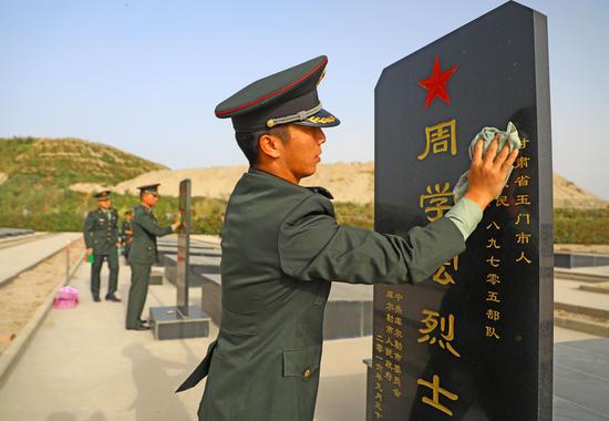 9月29日，新干部学员对烈士墓碑认真打扫。