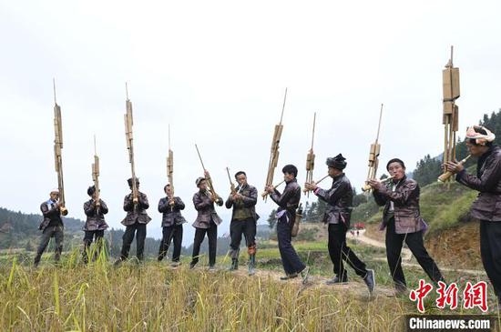 高增乡建华村侗族村民在吹奏芦笙为抢收香禾糯助兴。 吴德军 摄 高增乡建华村侗族村民在吹奏芦笙为抢收香禾糯助兴。 吴德军 摄