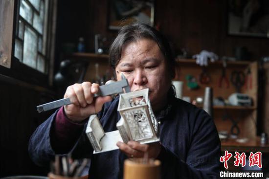 10月10日，银匠潘仕学在麻料村测量银饰产品。　瞿宏伦 摄