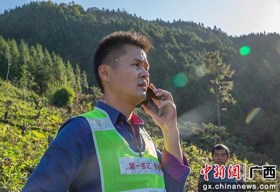 吴李东在田间地头为贫困户联系农产品销路。