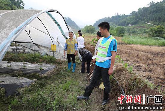 吴李东在田间跟贫困户研究做大脱贫产业。