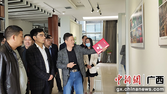 图为与会嘉宾参观摄影展。