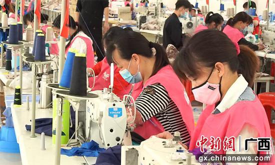 图为工人在靖美服装厂工作.