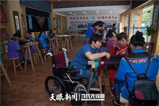 杨光荣双腿瘫痪,坐在轮椅上学习苗绣