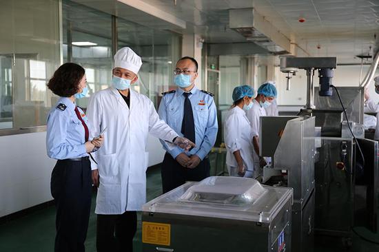 在昌吉市滨湖镇新疆丝路源疆馕文化产业园,工作人员为税务干部介绍环保智能馕生产设备。马娇娇 摄 在昌吉市滨湖镇新疆丝路源疆馕文化产业园,工作人员为税务干部介绍环保智能馕生产设备。马娇娇 摄