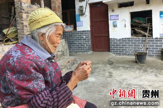姚喜英在院子里缝制口袋