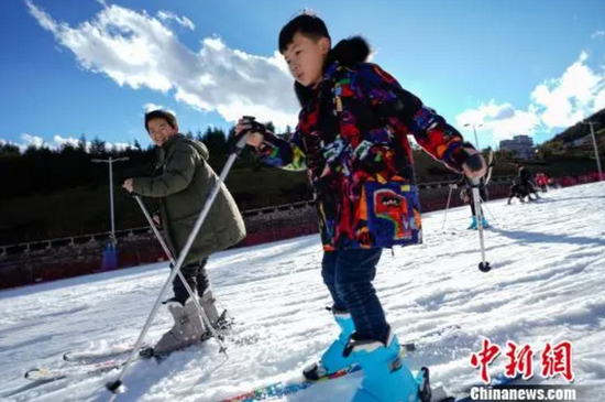 蓝天白云下,游客在六盘水体验滑雪。 贺俊怡 摄