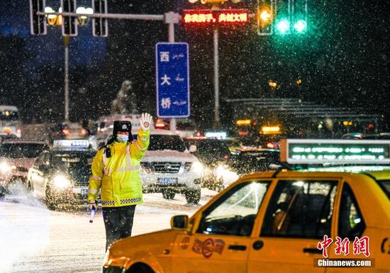 乌鲁木齐持续降雪道路湿滑 交警雪中坚守岗位
