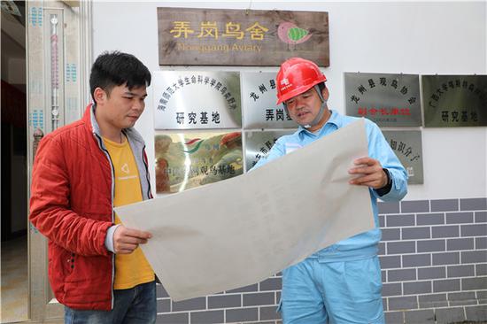 逐卜供电所工作人员向弄岗村村民介绍电费政策。刘晓峰 摄