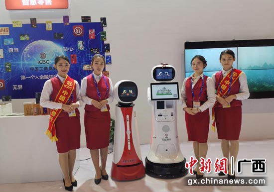 圖為智能機器人“工大壯”和“工小美”與禮儀人員一起迎賓。 圖為智能機器人“工大壯”和“工小美”與禮儀人員一起迎賓。