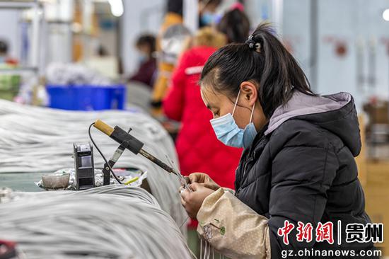 贵州省毕节市黔西县素朴镇环凯电子科技有限公司扶贫车间，村民在进行数据线手工焊锡作业。