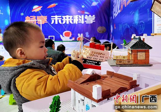 图为3岁的壮族小朋友黄建凯在广西河池市微科技馆里研究轮船的构造。高东风 摄 图为3岁的壮族小朋友黄建凯在广西河池市微科技馆里研究轮船的构造。高东风 摄