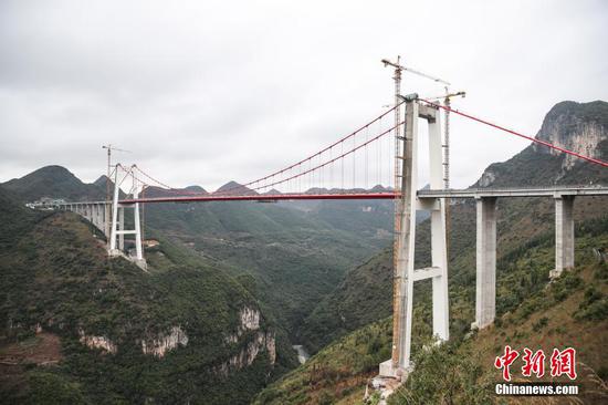 峰林特大桥是兴义环高项目上的特大桥之一,全长1163米,主跨采用550米悬索桥,桥面离谷底364.2米,是中国山区第一座大跨径钢混叠合梁悬索桥。 中新社记者 瞿宏伦 摄 峰林特大桥是兴义环高项目上的特大桥之一,全长1163米,主跨采用550米悬索桥,桥面离谷底364.2米,是中国山区第一座大跨径钢混叠合梁悬索桥。 中新社记者 瞿宏伦 摄