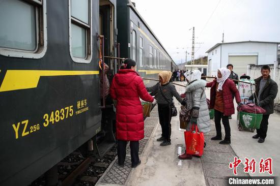 图为云南昭通南火车站,果农将苹果挑运上车 瞿宏伦 摄