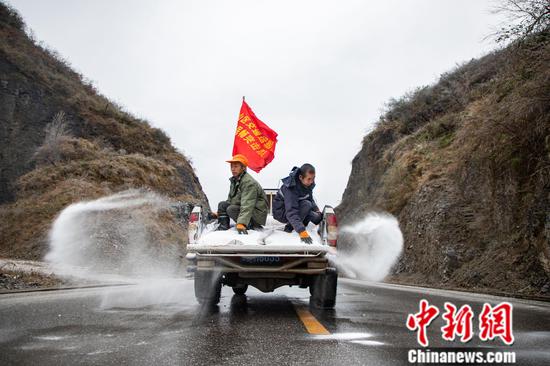 图为工作人员撒盐保障道路通行。肖浩 摄