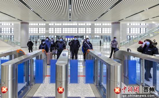 2020年12月15日,黔西县高铁站旅客在闸机口前等待上车指令。