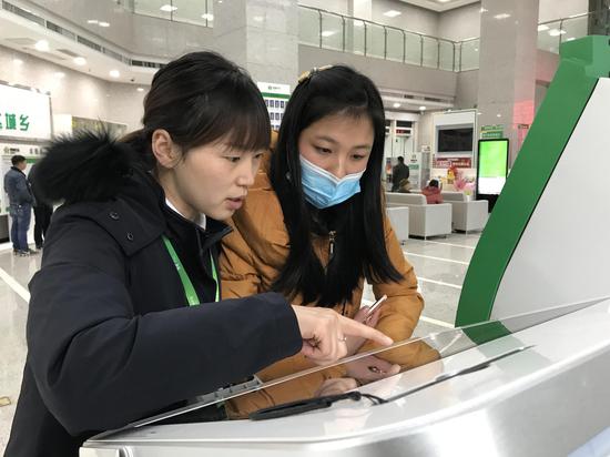 安龙农商银行工作人员引导客户使用智慧柜员机 安龙农商银行工作人员引导客户使用智慧柜员机