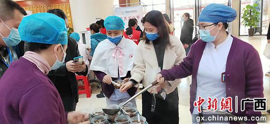 图为民众品尝现场熬制的各种养生汤。罗先彬 摄
