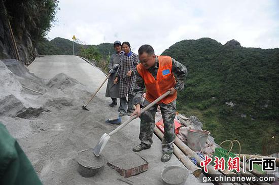 图为黄坚参加道路建设。谭慧武 摄 “清道夫”清掉脱贫致富“绊脚石” 极度贫困村走上特色发展之路