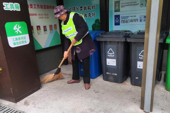 每次到岗，胡赛娥都会细心清理垃圾分类投放点的卫生。金华开发区垃圾分类办提供