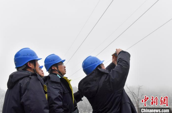 1月7日，贵阳供电局输电管理所驻点观冰员在开阳县双流镇用沙村巡线时用仪器测量覆冰数据。　乔啟明　摄