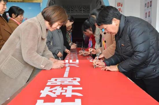 天台县街头镇新一届妇联主席在履新承诺上签名  王鹏飞 摄