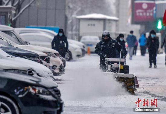 图为工作人员用机械扫雪车清理积雪。 中新社记者 刘新 摄